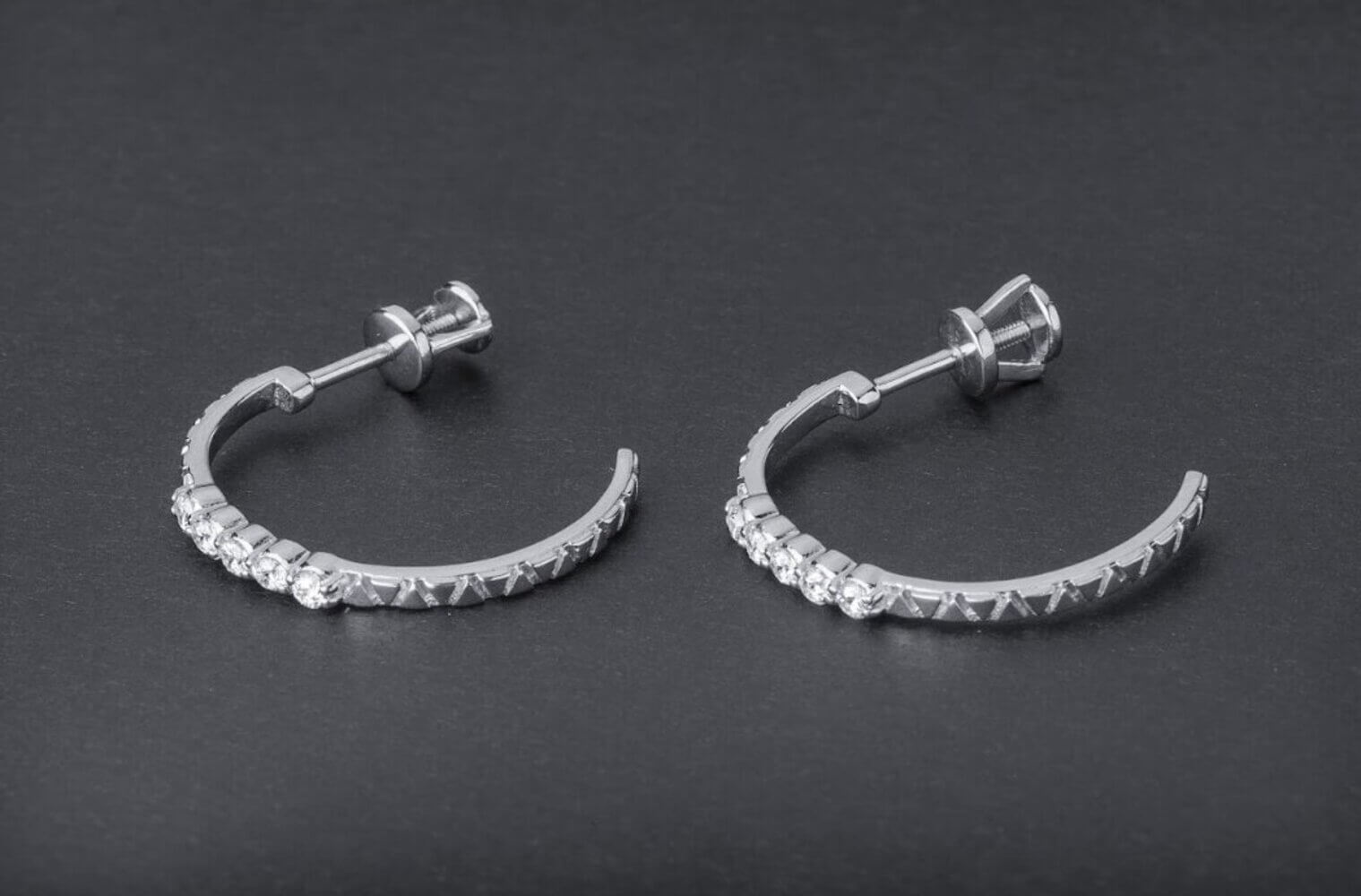 Silver crystal hoop earrings with geometric triangle patterns and clear stones