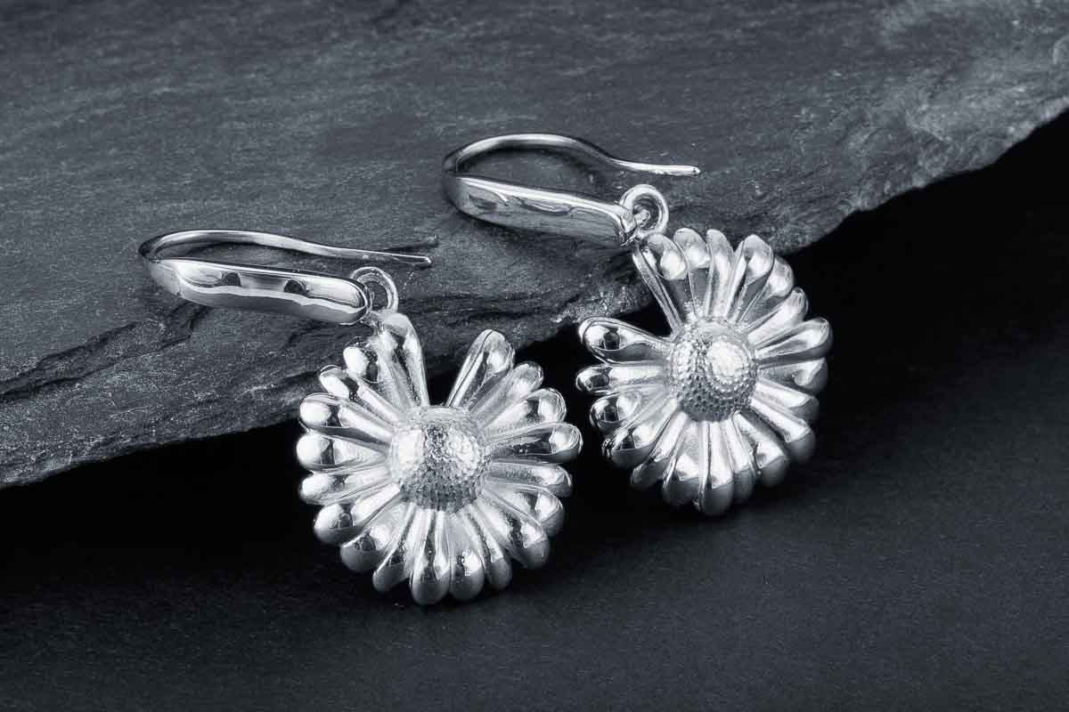 Silver daisy drop earrings with detailed petals and secure hoop closures