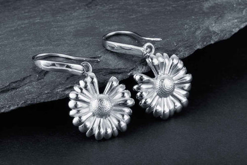 Silver daisy drop earrings with detailed petals and secure hoop closures