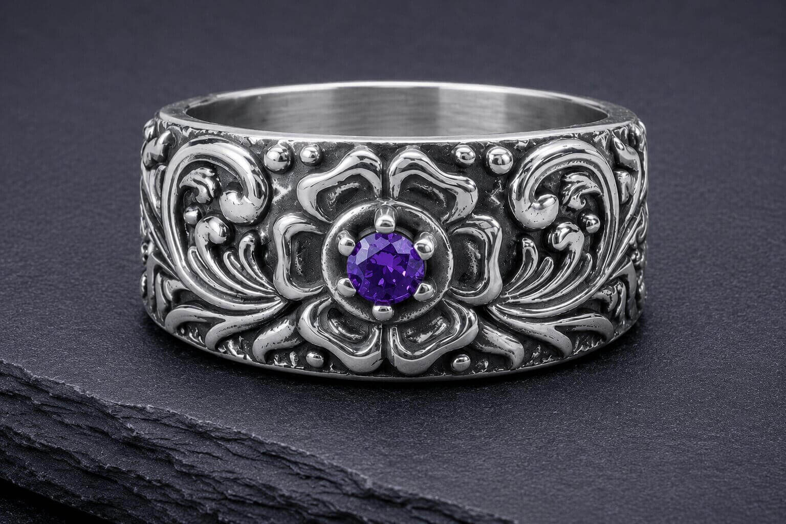 Silver floral band ring with amethyst stone surrounded by detailed vine and floral patterns