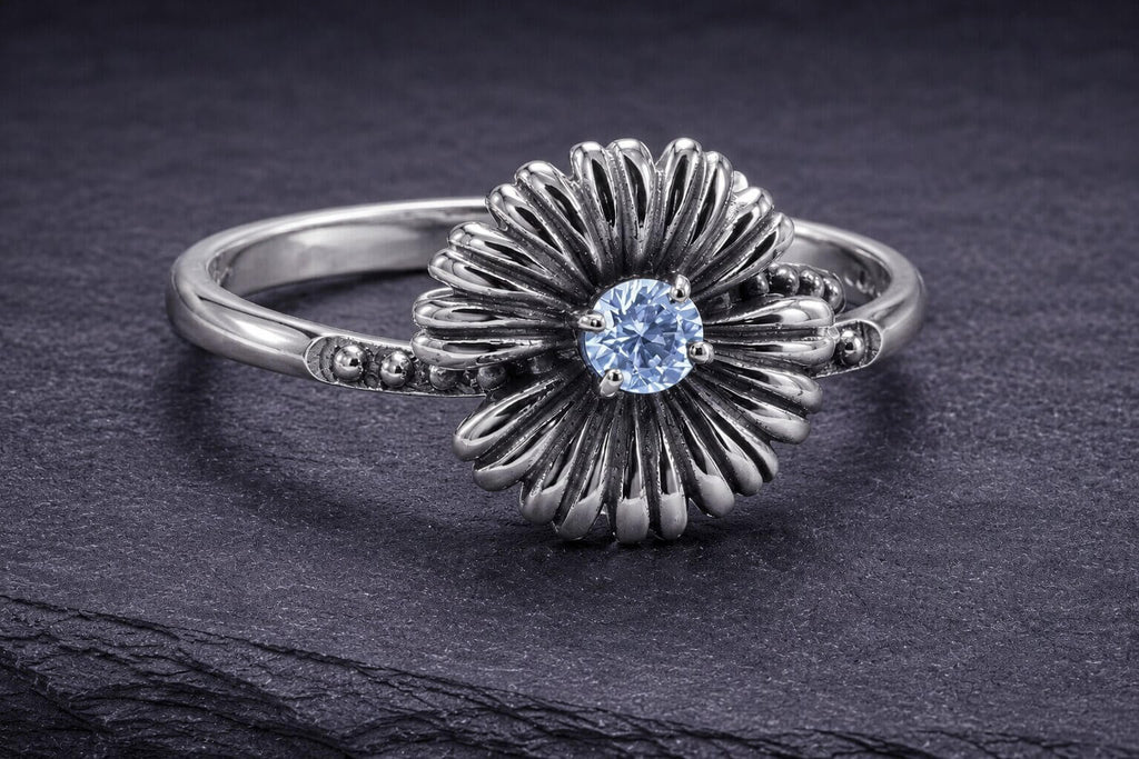 Sterling silver daisy ring with blue cubic zirconia center stone and detailed curved petal design