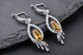 Sterling silver flame drop earrings with yellow cubic zirconia center stone and white cubic zirconia halo