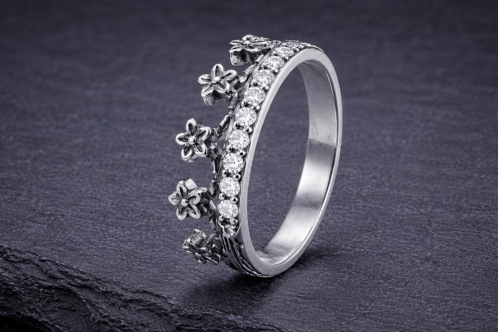 Sterling silver flower crown ring with detailed textured petals and cubic zirconia stone band