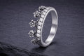Sterling silver flower crown ring with detailed textured petals and cubic zirconia stone band