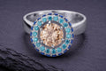 Sterling silver halo ring with champagne center stone and blue accent stones